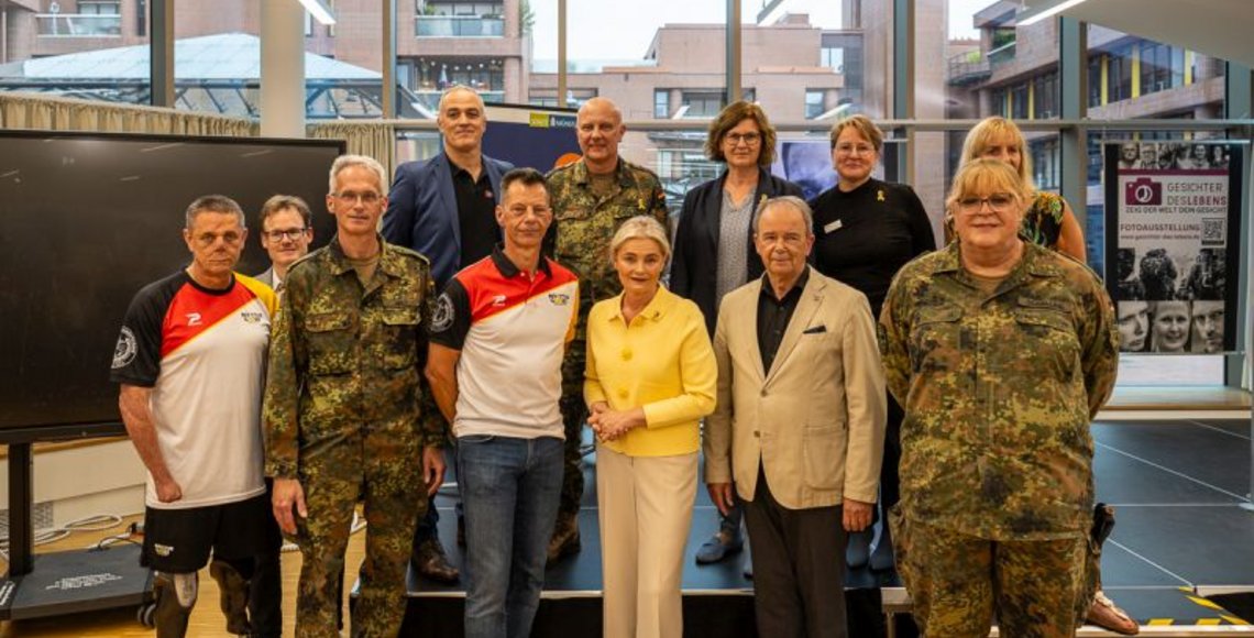 Das Gruppenfoto zeigt einige der am Ausstellungs- und Veranstaltungsprogramm in Münster beteiligten Kooperationspartner - v.l.n.r. Armin Witczak (Gesicht des Lebens), Jens Effkemann (Regionalgeschäftsführer des Volksbundes), Brigadegeneral Jens Arlt (Standortältester der Bundeswehr in Münster), Oberstabsfeldwebel a.D. Jürgen Görlich (1. Stellvertreter des Bundesvorsitzenden vom Deutschen Bundeswehrverband), Thomas Kroner (Gesicht des Lebens), Künstler Andreas Steinkat, Bürgermeisterin Angela Stähler (Stadt Münster), Pastorin Daniela Fricke (Evangelisches Militärpfarramt Münster), Generalleutnant a.D. Bruno Kasdorf (Vorsitzender des Kuratoriums der Soldaten- und Veteranenstiftung), Esther Joy Dohmen (Direktorin der VHS-Münster), Claudia Schalling (Gesicht des Lebens) und Daniela Skrzypczak (Fotografin und Ausstellungsmacherin). 